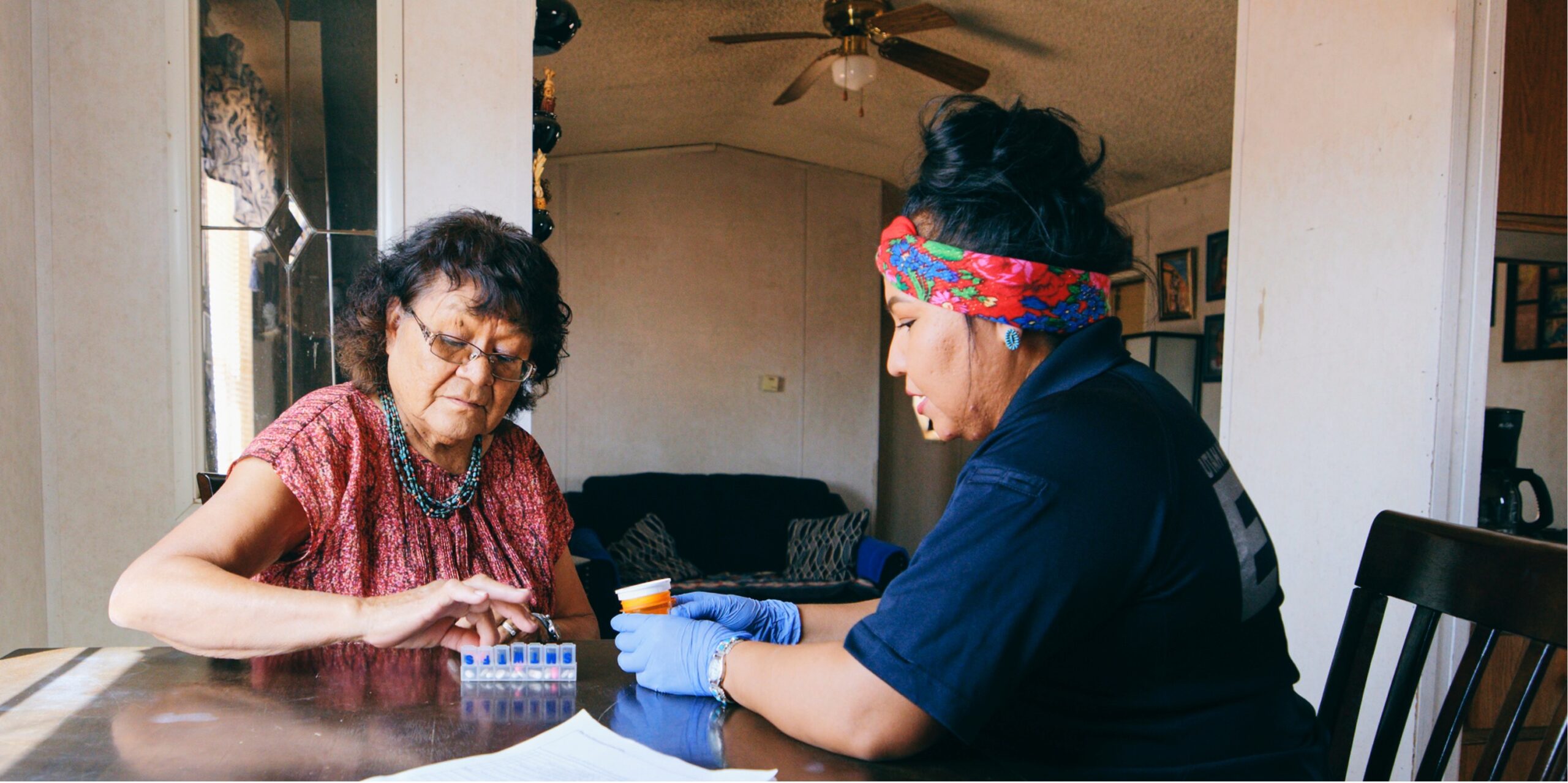 Nurse helping elder with vitamins